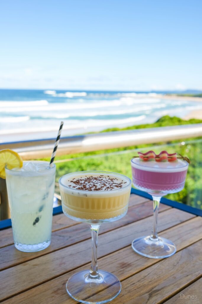 Cocktails on the balcony at Dunes by Dish overlooking Soldiers Beach